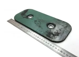 Placă metalică verde cu două găuri și riglă metrică